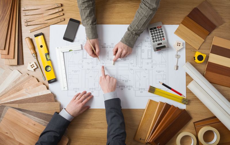 Project plans, laptop and scale rulers on a desk